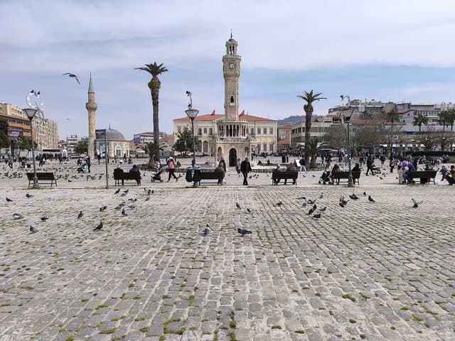 İzmir Clock Tower in Konak Square, with palm trees and Yalı Mosque